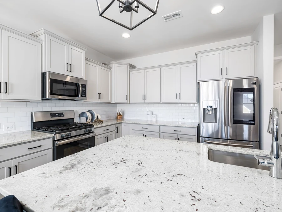 Granite kitchen inspiration with light cabinetry and a pendant-lit island