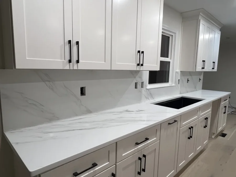 White quartz counters with a matching full-height backsplash